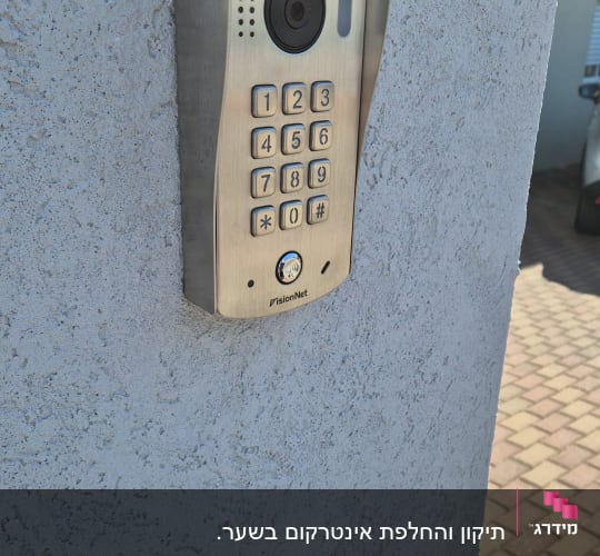 אינטרקום עם מצלמה ומקשים על קיר חיצוני
